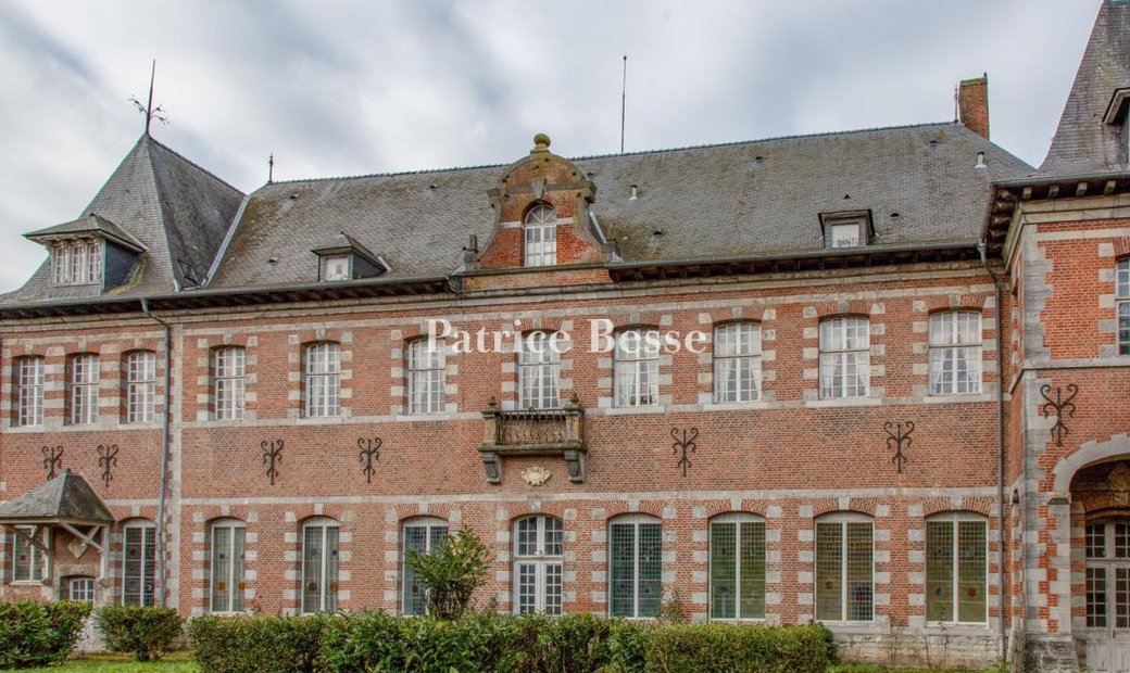 A Vast Brick And Stone Mansion With A 20th Century Extension, In The Middle Of A Small Town In